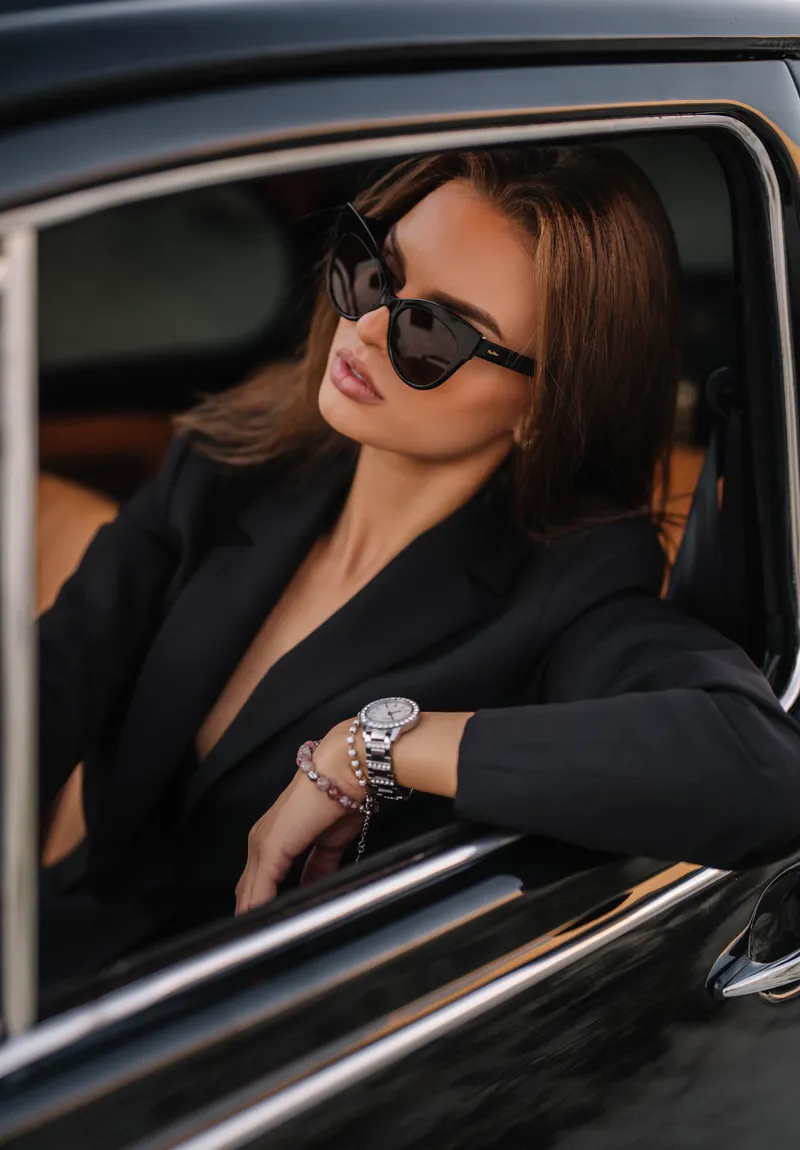 An executive in a tailored jacket seated in a car